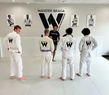 Junior students drilling jiu-jitsu techniques with their black belt coach